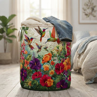 Mand op een houten vloer in de slaapkamer, gevuld met een gebreide trui en een spijkerbroek, met kolibries en bloemen. 4