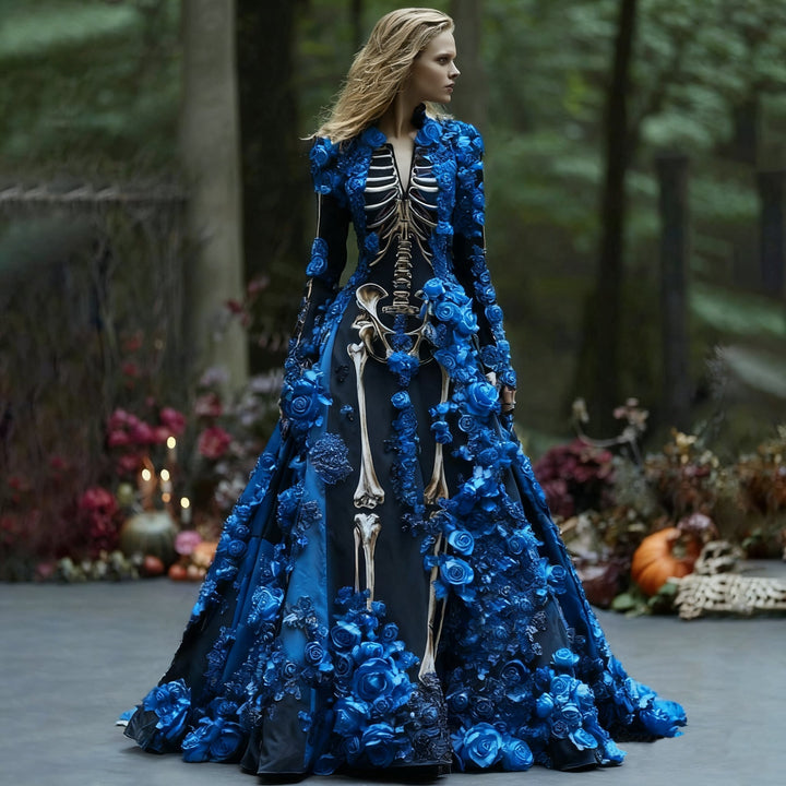 Model in de zwarte skeletjurk met lange mouwen en blauwe 3D-bloemen, zijwaarts kijkend tussen bomen en herfstdecoratie. 3