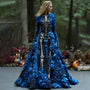 Model in de zwarte skeletjurk met lange mouwen en blauwe 3D-bloemen, zijwaarts kijkend tussen bomen en herfstdecoratie. 3
