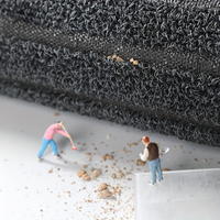 Opgerolde mat van opzij met zichtbare ondergrond, en miniatuurfiguurtjes die vuilkorrels vegen en scheppen. 6