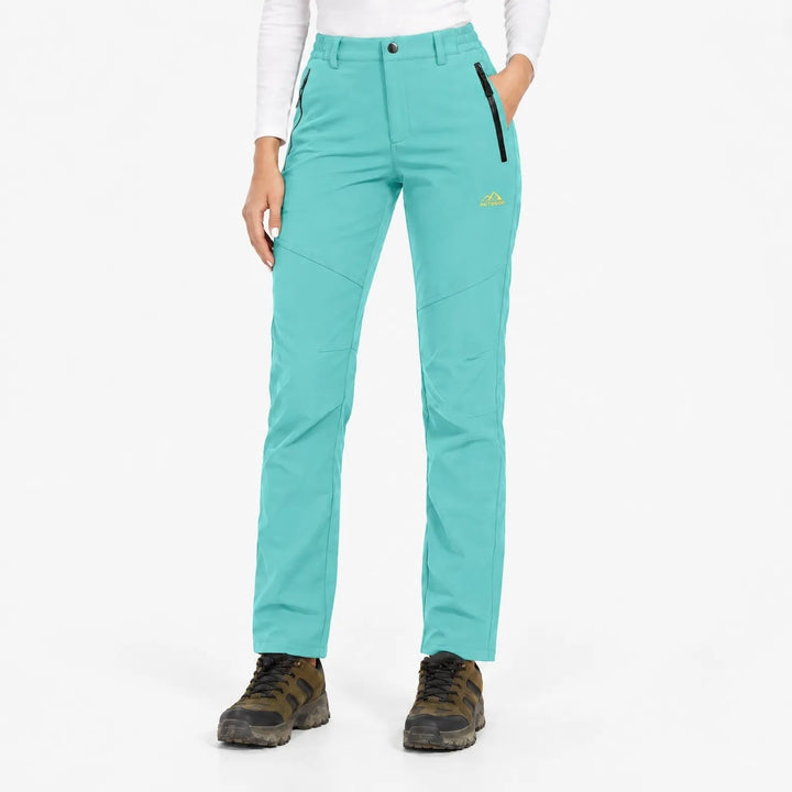 Voorkant van de turquoise broek met zwarte ritszakken, gedragen met wandelschoenen 19