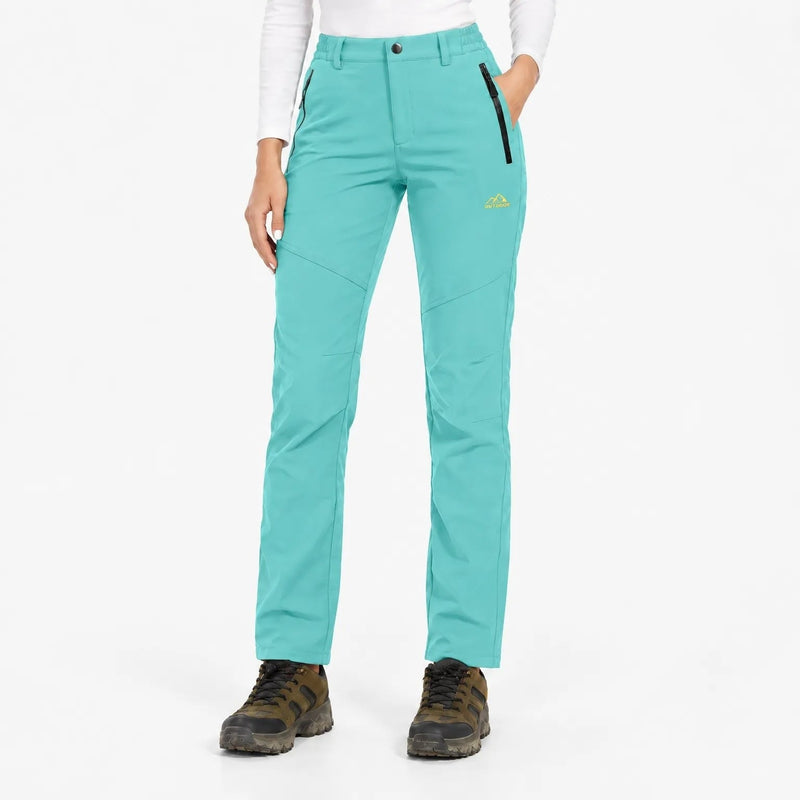 Voorkant van de turquoise broek met zwarte ritszakken, gedragen met wandelschoenen 19