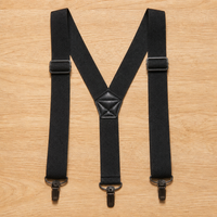 Zwarte Y-bretels met drie metalen clips, verstelbare schuiven en een gestikt kunstleren middenstuk op een houten tafel. 7