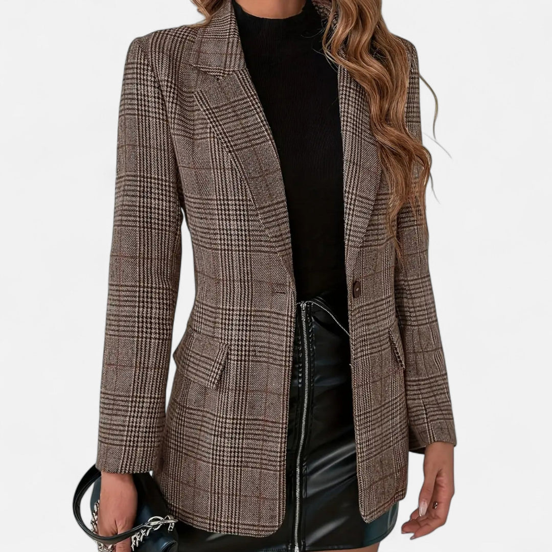 Voorkant van de bruine geruite blazer, open gedragen over een zwarte coltrui en een zwarte kunstleren rok, met klepzakken en een knoop. 1