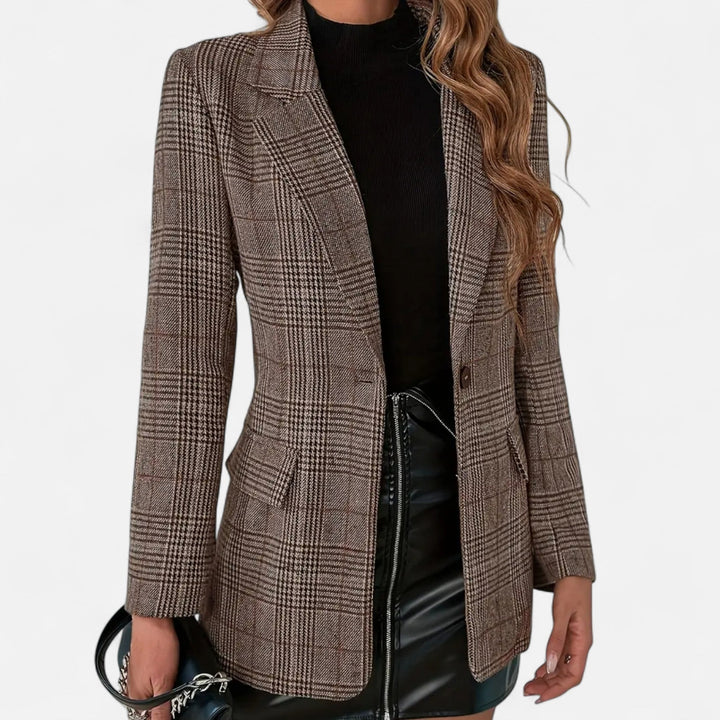 Voorkant van de bruine geruite blazer, open gedragen over een zwarte coltrui en een zwarte kunstleren rok, met klepzakken en een knoop. 1