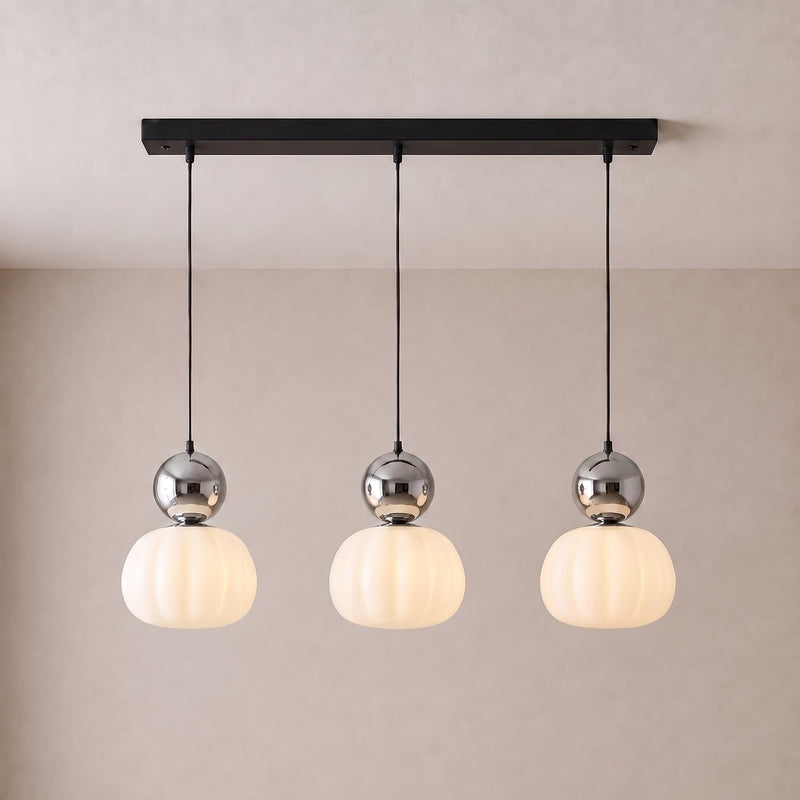 Driedelige hanglamp met drie chromen bollen en geribbelde witte kappen aan een zwarte langwerpige plafondplaat 9
