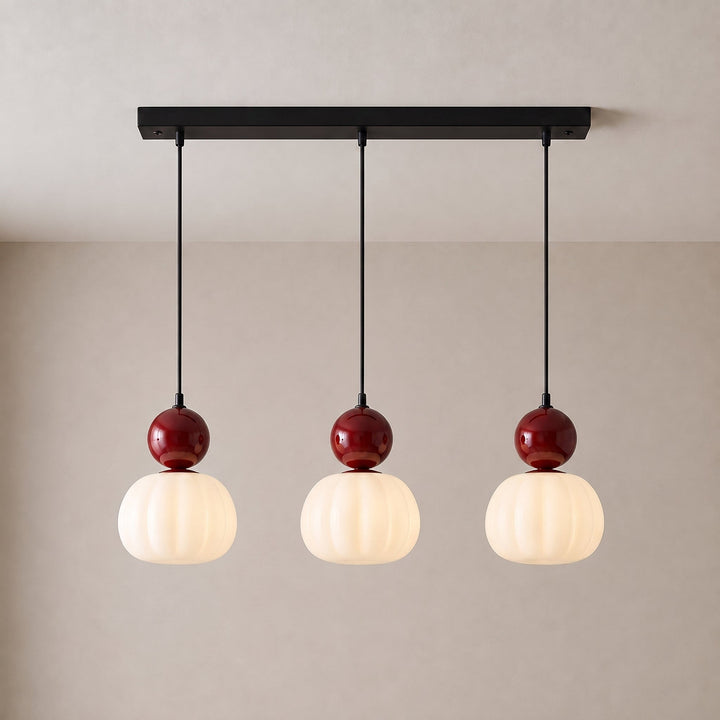 Driedelige hanglamp met drie rode bollen en geribbelde witte kappen aan een zwarte langwerpige plafondplaat 11