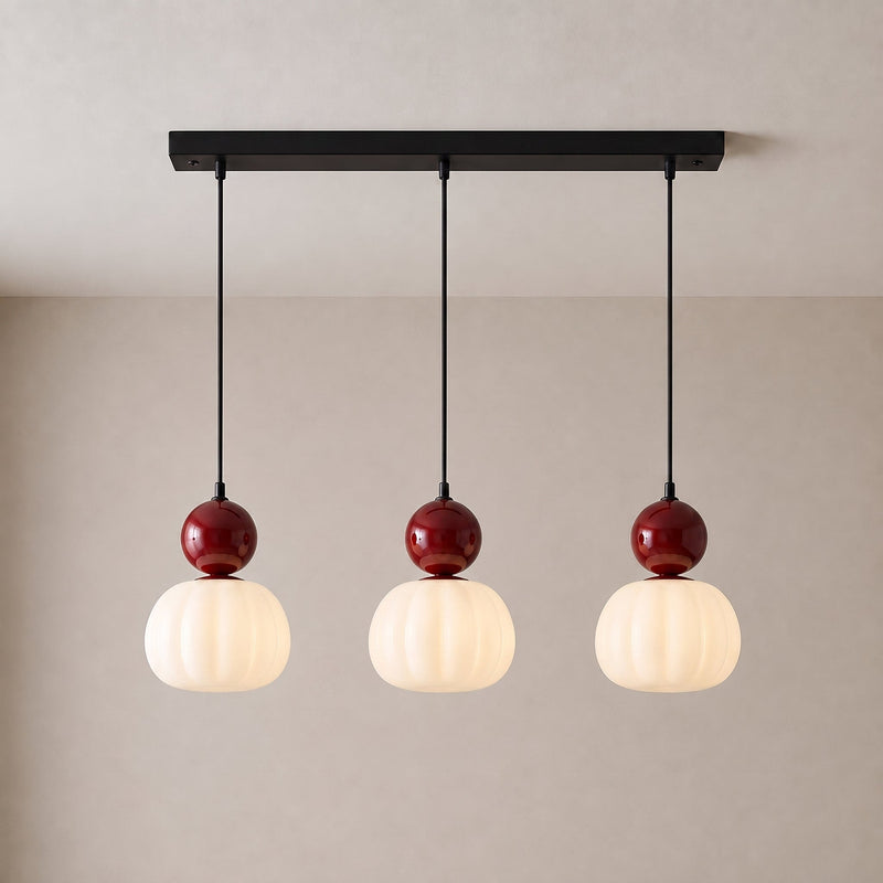 Driedelige hanglamp met drie rode bollen en geribbelde witte kappen aan een zwarte langwerpige plafondplaat 11