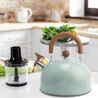 Mintgroene fluitketel op een keukenblad naast een hakmolen, met een schaal sla erachter 4