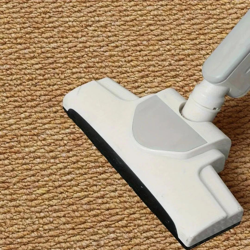 Close-up van een stofzuigerzuigmond op de bruine luspoolstof van de badmat 8