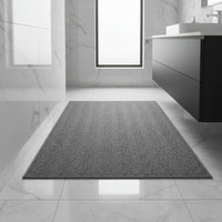 Donkergrijze badmat met afgewerkte rand op glanzende marmeren vloer in een moderne badkamer 1