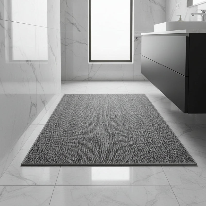 Donkergrijze badmat met afgewerkte rand op glanzende marmeren vloer in een moderne badkamer 1