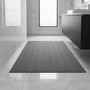 Donkergrijze badmat met afgewerkte rand op glanzende marmeren vloer in een moderne badkamer 1