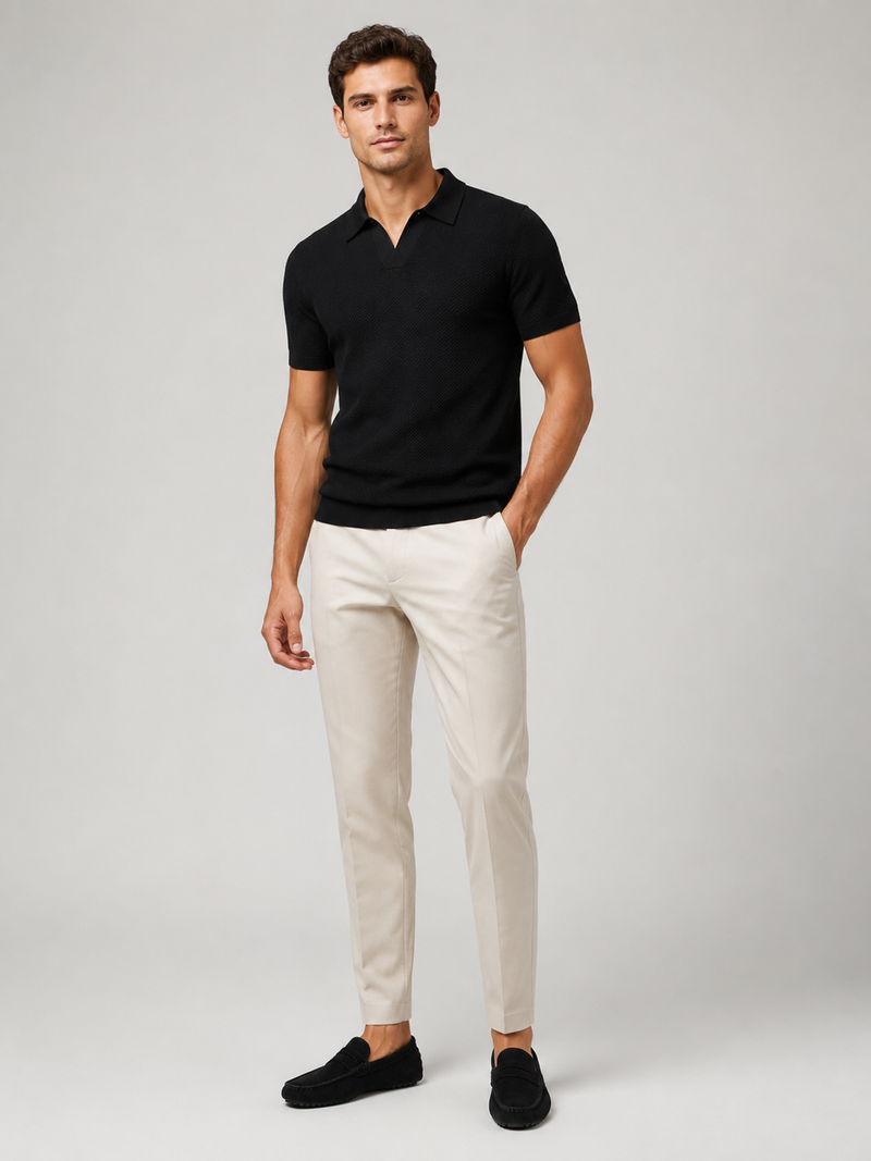 Zwart poloshirt in volledig model van voren, gedragen met crèmekleurige broek en zwarte suède loafers 8