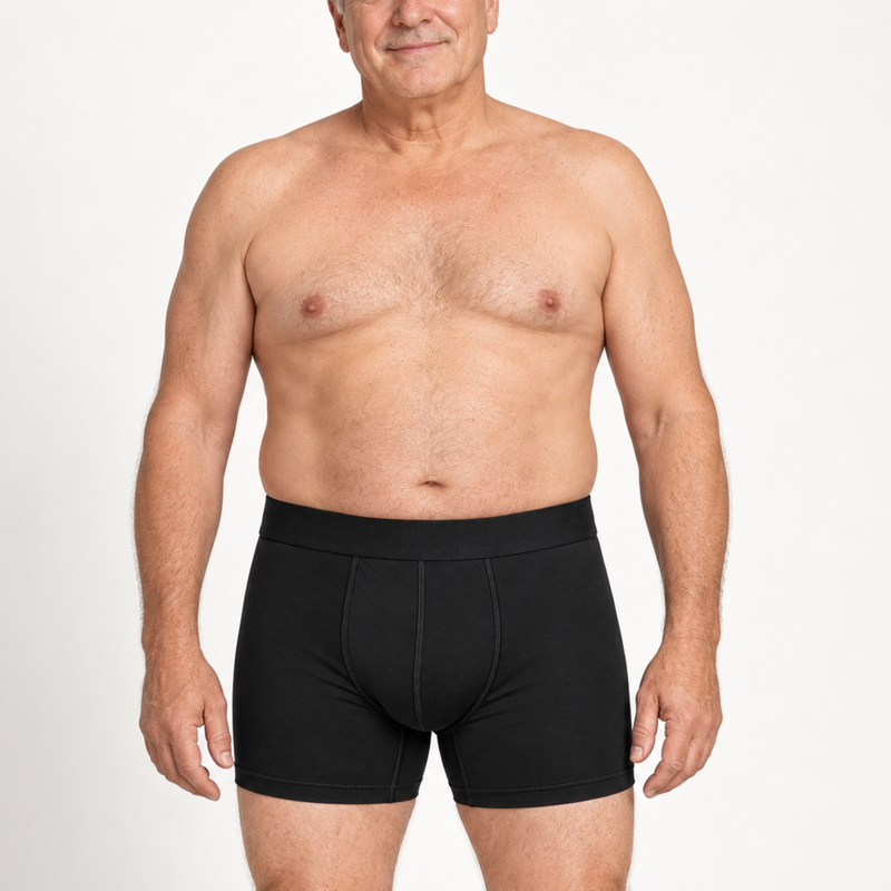 Oudere man met grijs haar draagt de zwarte boxershort, getoond van voren in staande houding tegen een witte achtergrond. 2