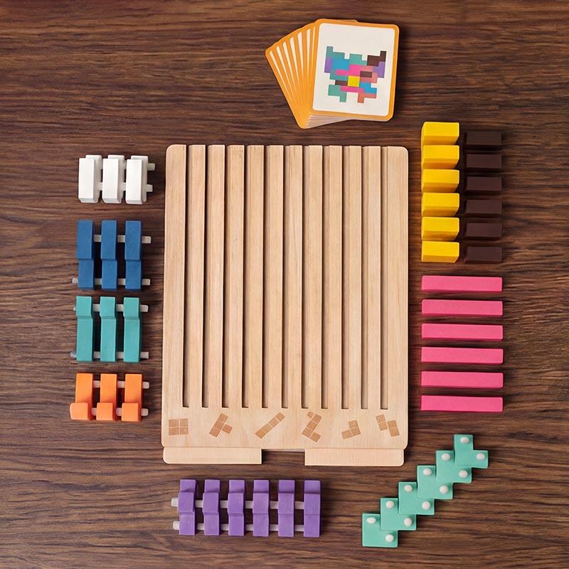 Bovenaanzicht van alle onderdelen op een houten tafel: leeg bord, gesorteerde gekleurde blokken met pennetjes en een stapel opdrachtkaarten. 2