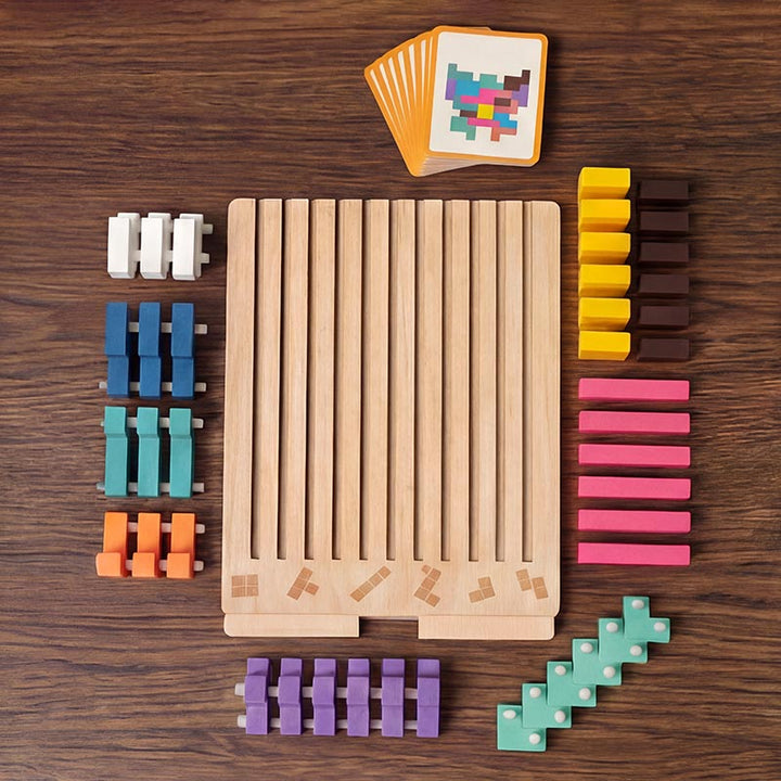 Bovenaanzicht van alle onderdelen op een houten tafel: leeg bord, gesorteerde gekleurde blokken met pennetjes en een stapel opdrachtkaarten. 2