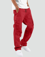 Model draagt de cargobroek in rood met zijzakken en trekkoord, voor een lichtgrijze achtergrond, met wit shirt en witte sneakers. 10