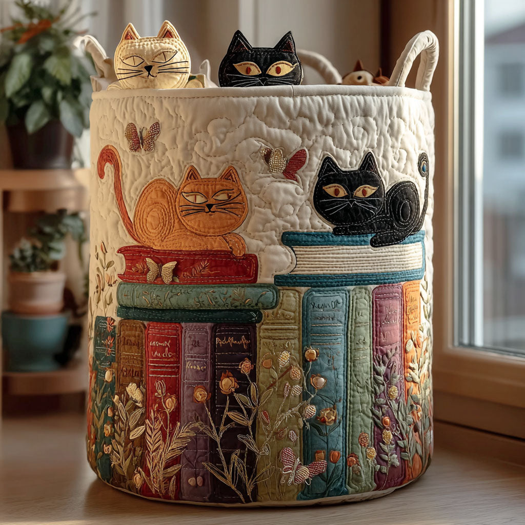 Ronde gequilte opbergmand met twee handvatten, versierd met een oranje en een zwarte kat op boekenstapels, bloemen en vlinders, naast een raam. 1