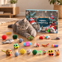 Grijze kat ligt op een houten vloer te spelen met een balletje, naast de adventskalenderdoos en de uitgestalde kleurrijke speeltjes. 1