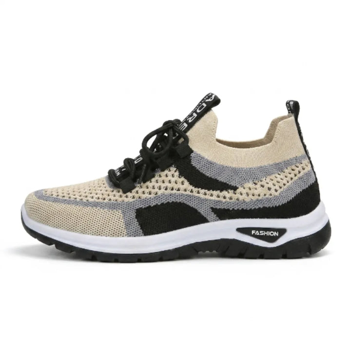 Zijaanzicht van de beige sneaker met zwarte en grijze gaasdelen, zwarte veters, witte tussenzool en zwarte loopzool. 37