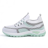Zijaanzicht van de sneaker in wit met mintgroene zool en grijze accenten, met elastische veters. 10
