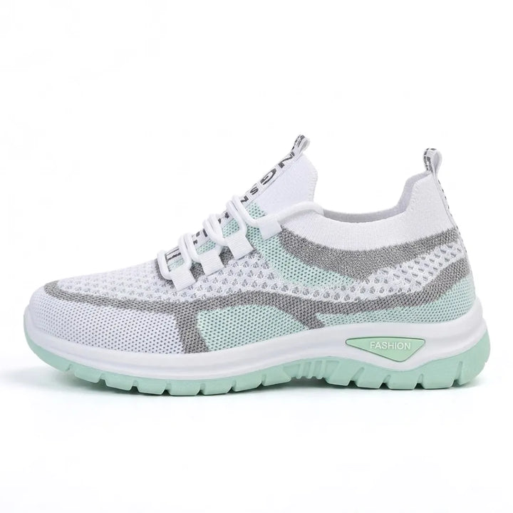 Zijaanzicht van de sneaker in wit met mintgroene zool en grijze accenten, met elastische veters. 10