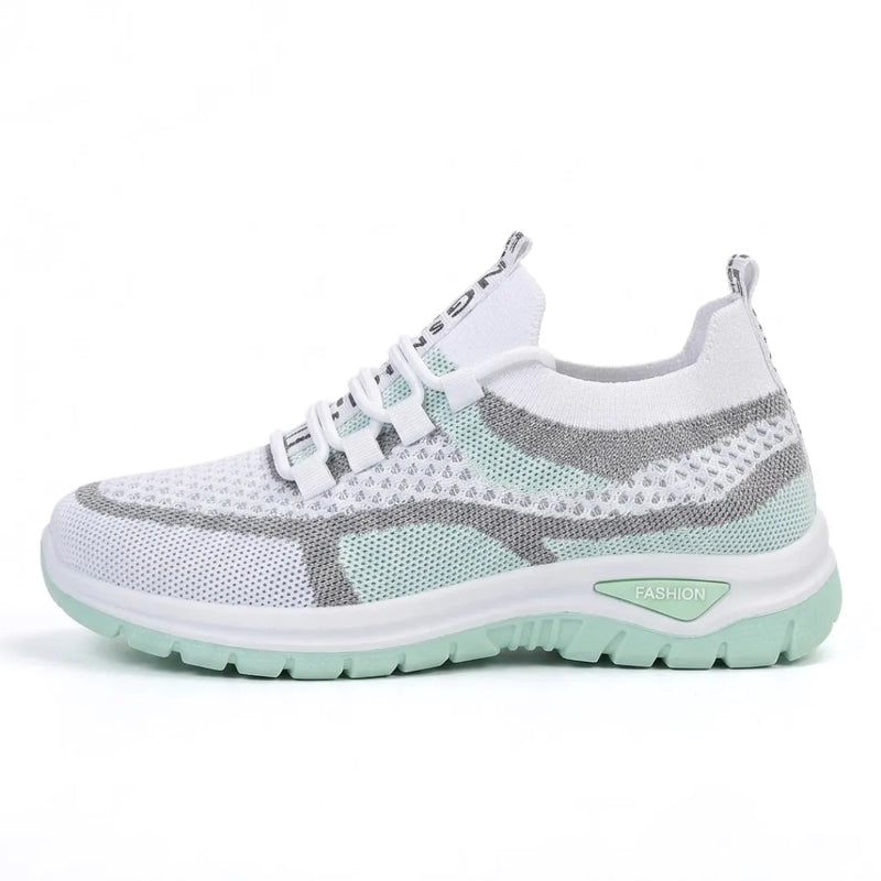 Zijaanzicht van de sneaker in wit met mintgroene zool en grijze accenten, met elastische veters. 10
