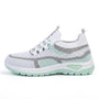 Zijaanzicht van de sneaker in wit met mintgroene zool en grijze accenten, met elastische veters. 10