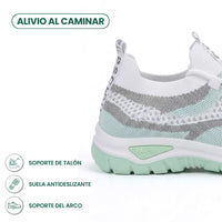 Close-up van hiel en zool van de witte sneaker met mintgroene zool, met pictogrammen voor hielsteun, antislipzool en booggewelfsteun. 13