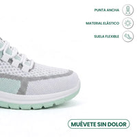 Close-up van de brede neus van de witte sneaker met mintgroene zool en pictogrammen voor ruime neus, elastisch materiaal en flexibele zool. 14