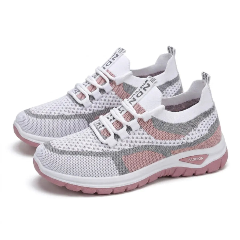 Paar witte sneakers met roze en grijs gaas en roze zool, schuin van opzij gefotografeerd op een witte achtergrond. 25