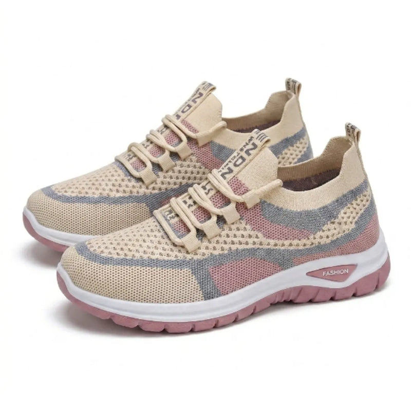 Paar beige sneakers met roze en grijs gaas, witte tussenzool en roze loopzool, schuin van opzij gefotografeerd. 34