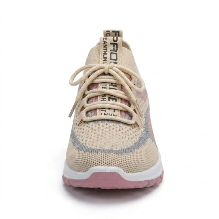 Voorkant van de beige sneaker met veters, roze en grijze details en een brede, ronde neus. 35