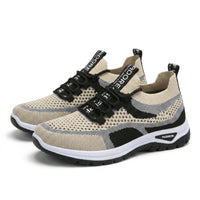 Paar beige sneakers met grijze en zwarte accenten, zwarte veters en witte zool, schuin van voren gezien. 43