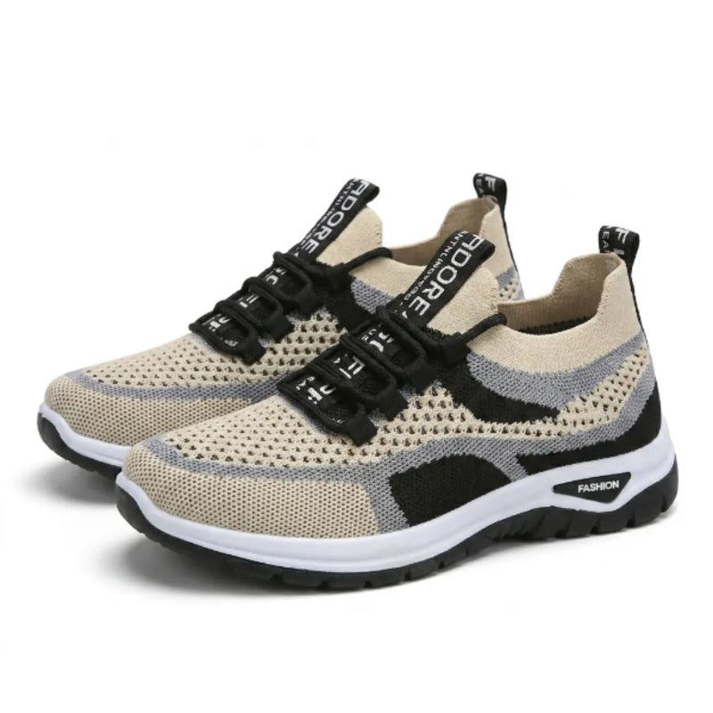 Paar beige sneakers met grijze en zwarte accenten, zwarte veters en witte zool, schuin van voren gezien. 43