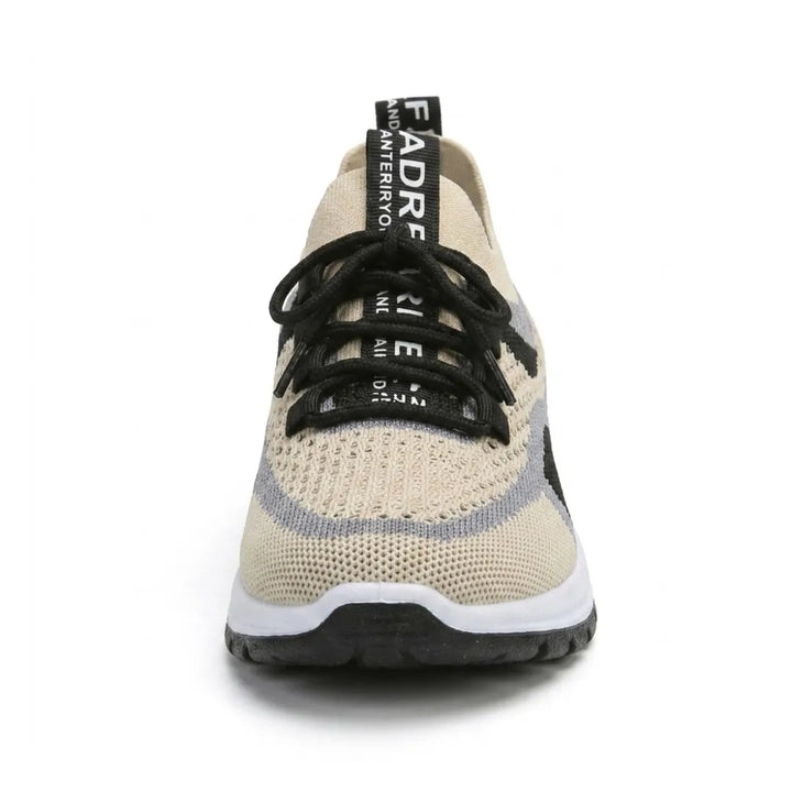 Beige gaas-sneaker recht van voren gefotografeerd, met zwarte veters, grijze rand, hielband en dikke witte zool met zwart profiel. 44