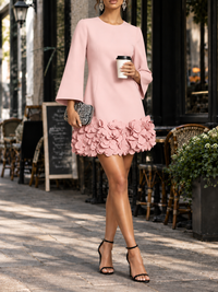 Roze jurk gedragen voor een terras, model met koffiebeker en avondtasje, 3D-bloemen aan de zoom 12