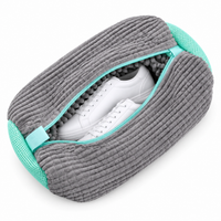 Grijze waszak van geribbelde pluche met turquoise gaasdelen, rits open met witte sneakers zichtbaar 10