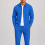 Model draagt de set in felblauw met wafelstructuur, jack open over wit shirt, horloge om de pols 5