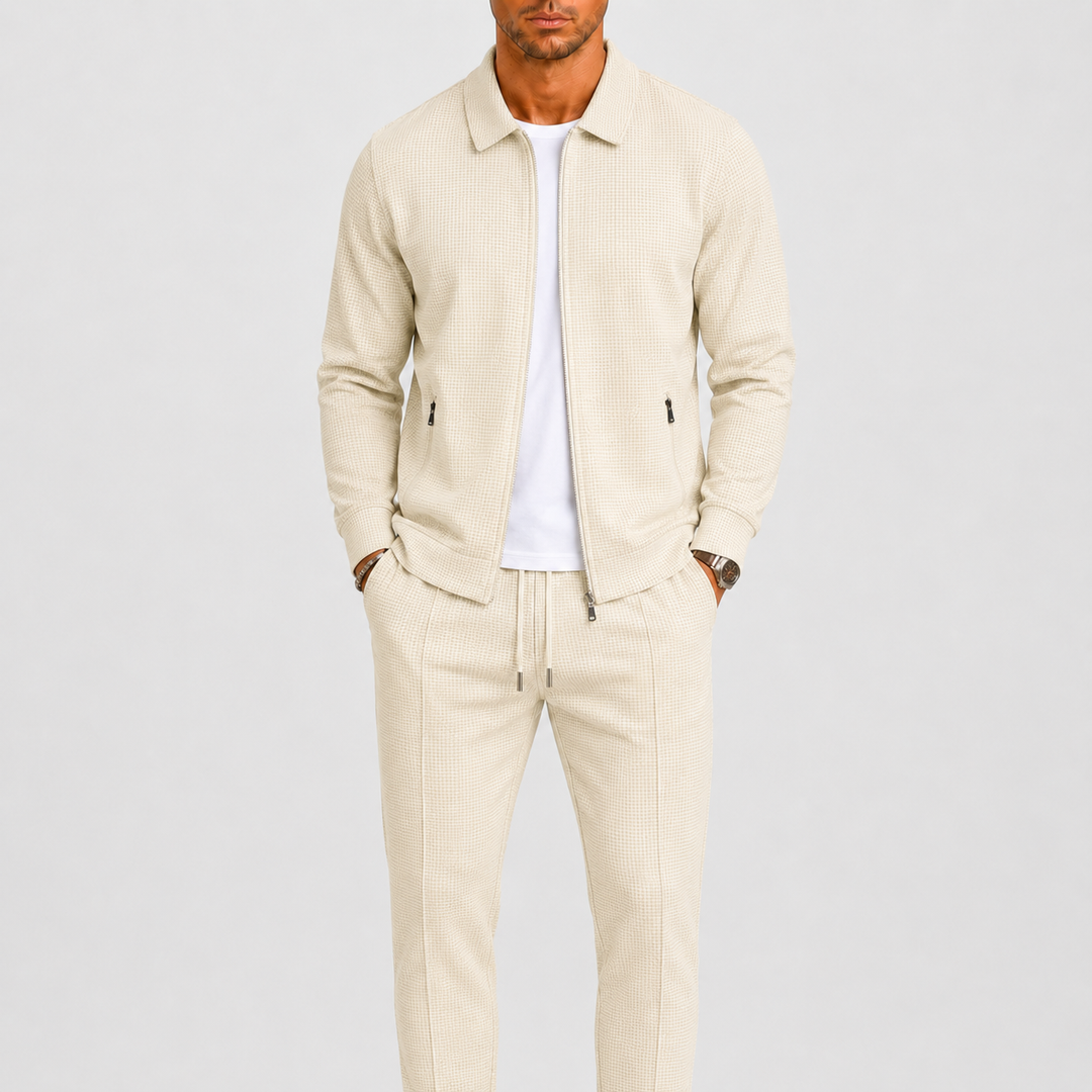 Model draagt de set in crèmebeige met wafelstructuur, open jack over wit shirt, handen in zakken 1