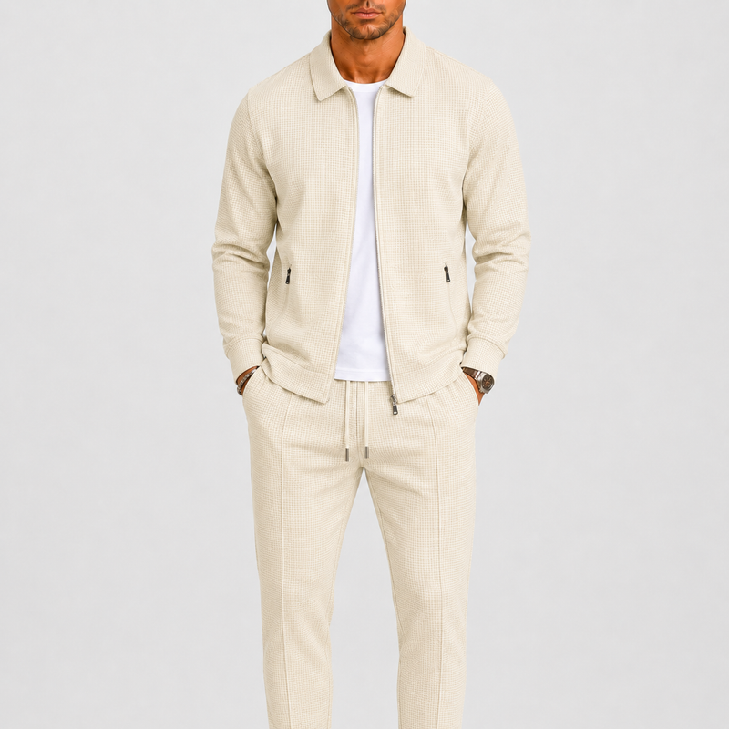Model draagt de set in crèmebeige met wafelstructuur, open jack over wit shirt, handen in zakken 1