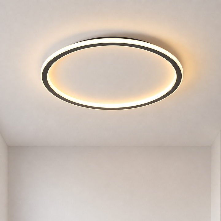 Brandende ronde plafondlamp met zwarte rand en warm licht, recht van onderen gezien tegen een kaal wit plafond. 1