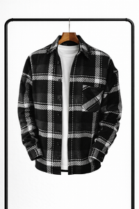 Zwart-wit geruit overhemd aan een houten hanger, open over een wit T-shirt, met borstzak en donkere knopen. 3