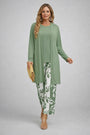 Model in saliegroen effen vest en top met wijde broek met witte bladerprint 3