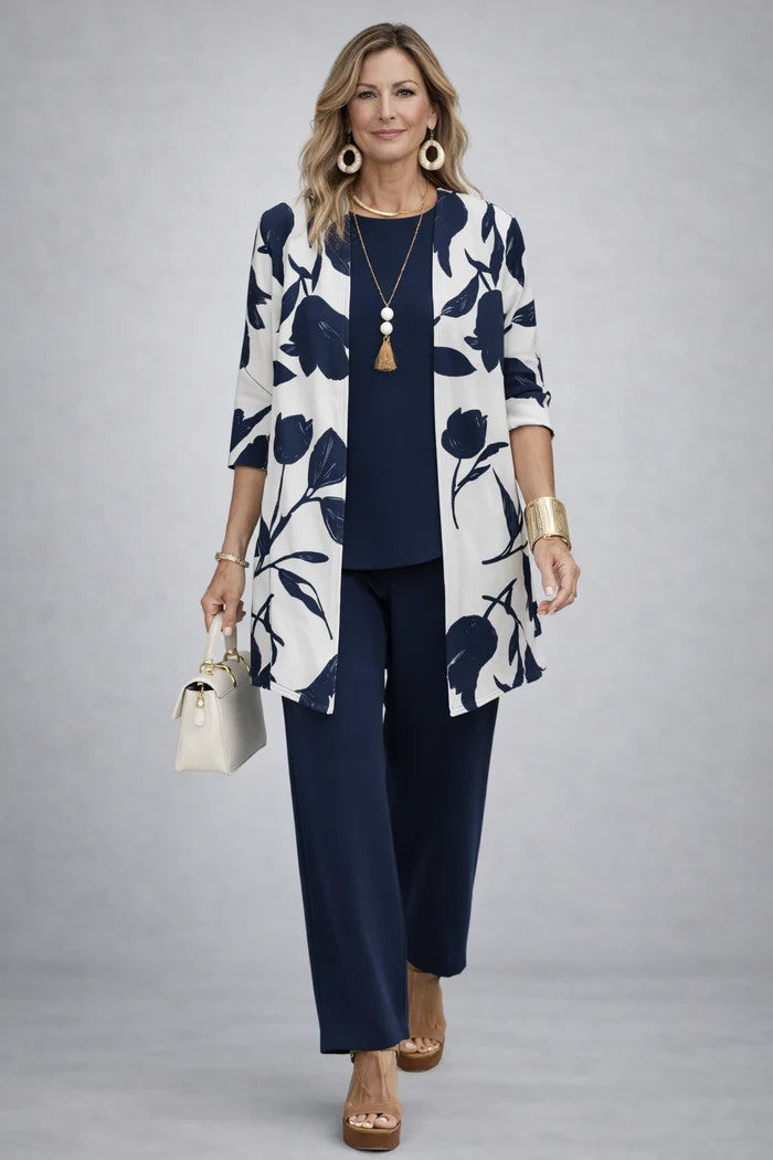 Model in marineblauwe top en broek met wit open vest met grote blauwe bloemenprint 8