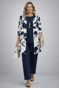 Model in marineblauwe top en broek met wit open vest met grote blauwe bloemenprint 8