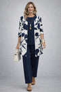 Model in marineblauwe top en broek met wit open vest met grote blauwe bloemenprint 8