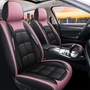 Twee voorstoelen met zwart-roze leerlook hoezen, roze hoofdsteunen en roze zijranden, met lichte stiksels, in een auto-interieur. 14