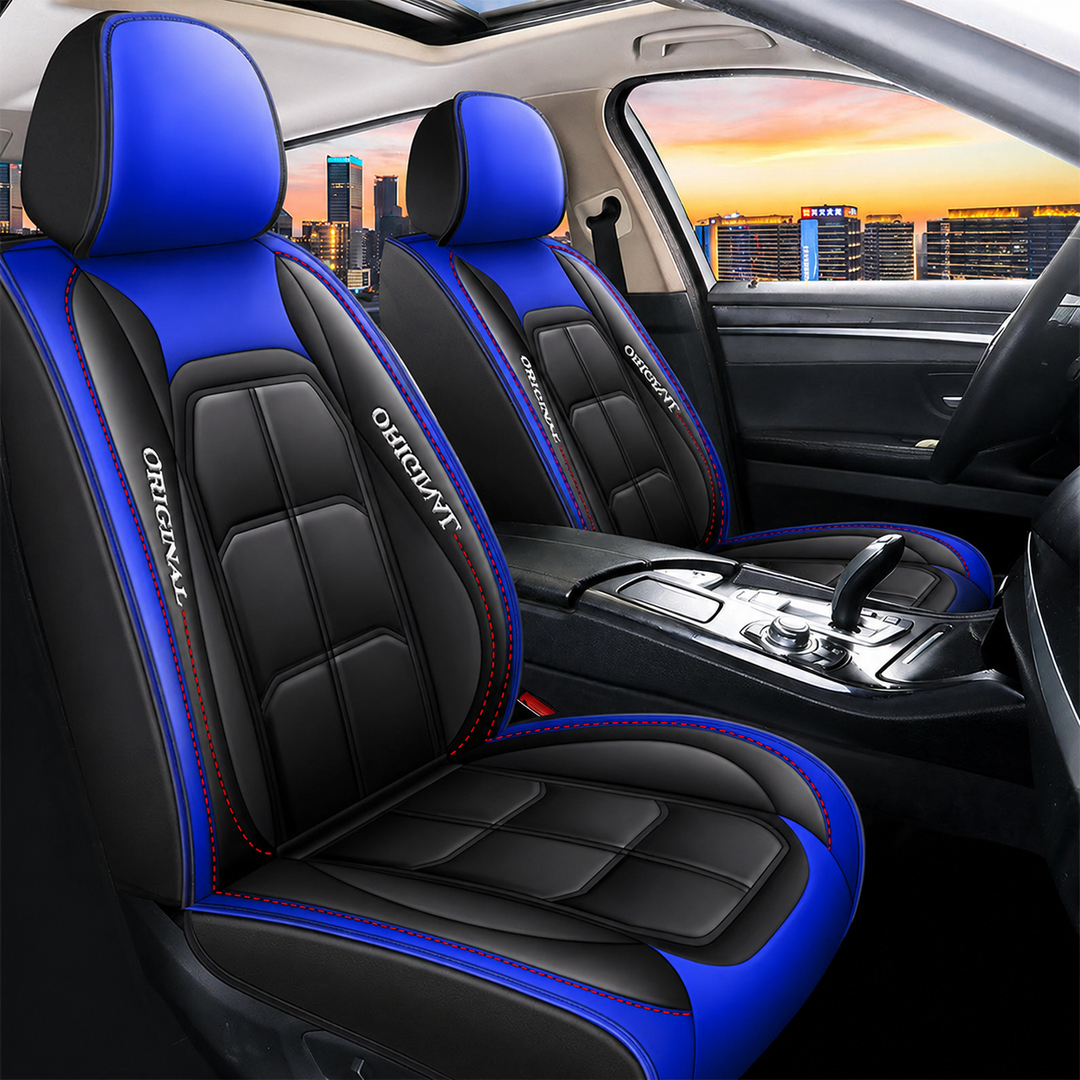 Twee voorstoelen met zwart-blauwe leerlook hoezen, blauwe hoofdsteunen en zijranden, met rode stiksels in een auto-interieur. 16